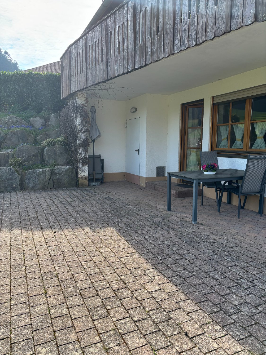 Hausseite mit Terrasse und Pflasterweg
