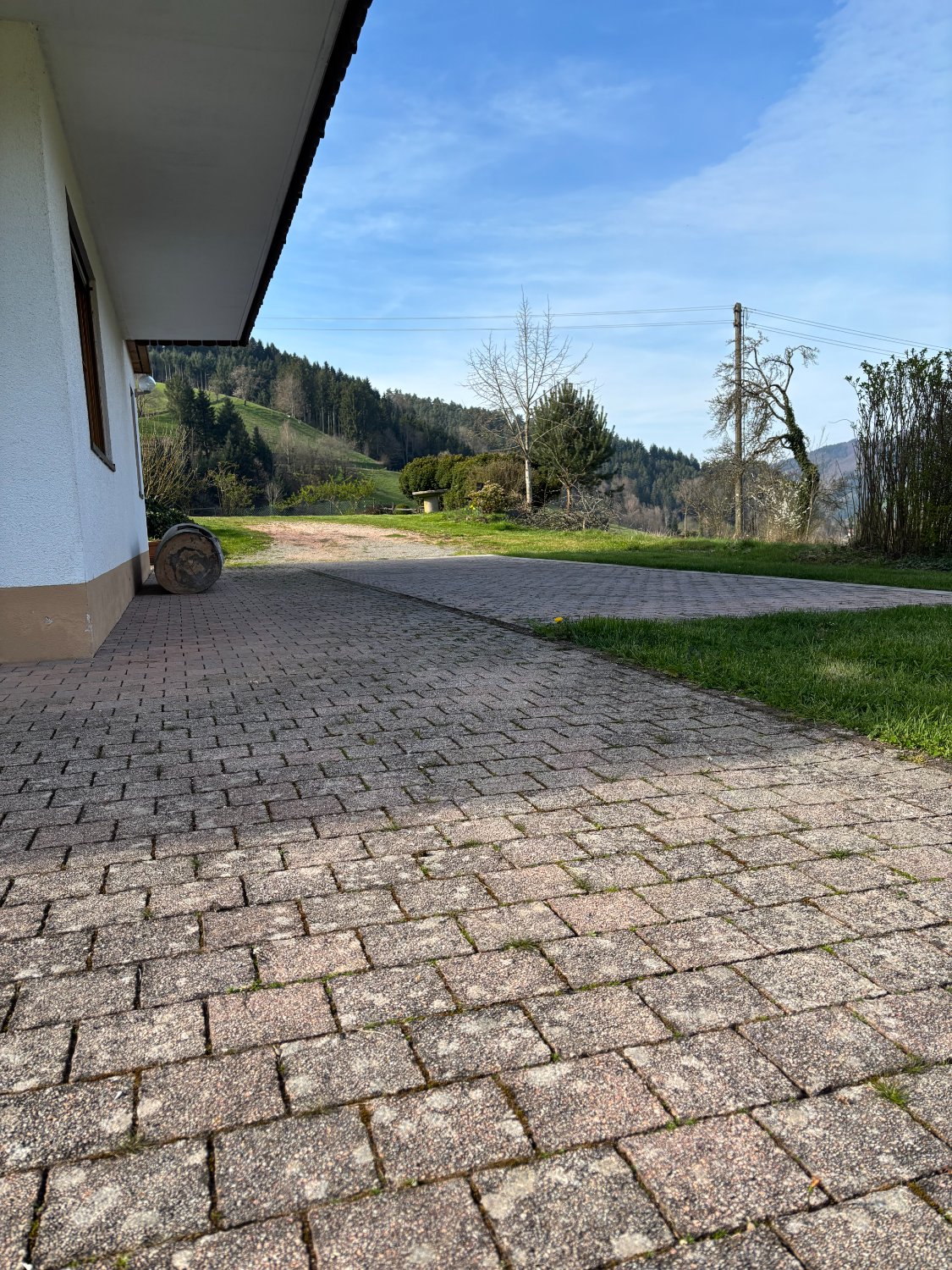 Gepflasterter Parkplatz neben dem Haus mit Blick ins Tal